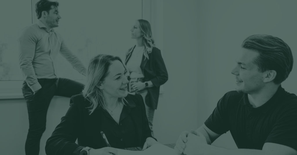 Denise Kromeich CEO sitting with employees and diskussion real estate investments